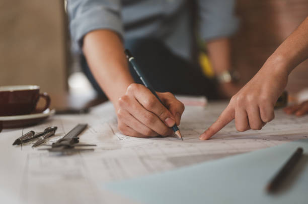 istock drawing line to measurement for create architecture building blueprint. engineer is meeting. 1551166116