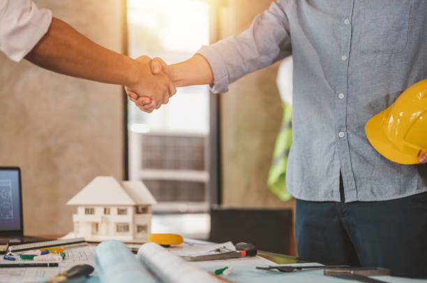istock engineers shake hands for meet up and brainstorm to prepare blueprint architecture project builder. 1551172177