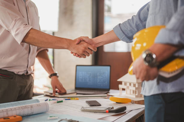 istock engineers shake hands for meet up and brainstorm to prepare blueprint architecture project builder. 1551173815