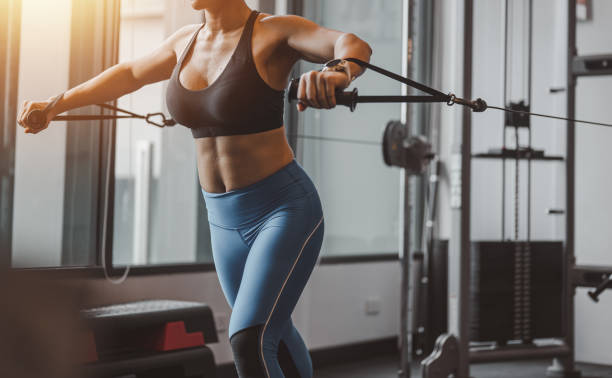 frau sportliches training auf multi-station im fitnessstudio für gesundheit und körpermuskeln. fitnessübung im fitnessstudio - carpet stretcher stock-fotos und bilder