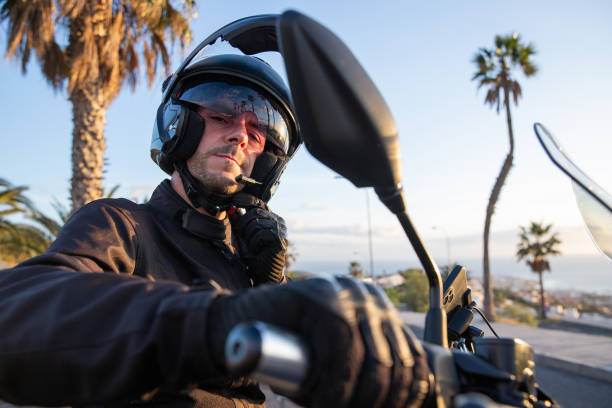 istock A motorcyclist puts on his helmet before setting off on a road trip on his motorcycle 1551208762