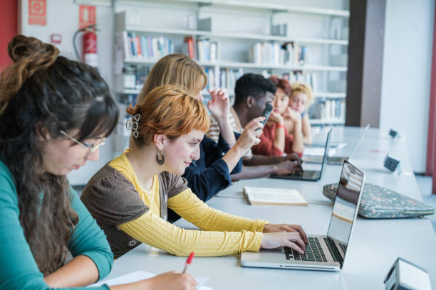 istock Group of college students studying together in the library 1551211898