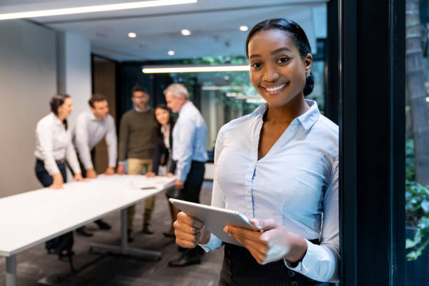 istock Successful businesswoman working with her team at the office using a tablet 1551218789