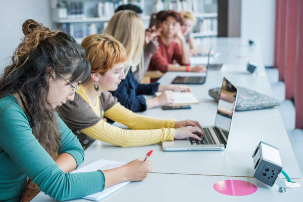 istock Group of college students studying together in the library 1551221706