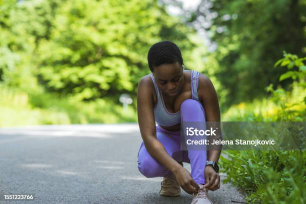 Shot Of A Sporty Young Woman Tying Her Shoelaces Before Her Run Stock Photo - Download Image Now