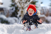 Young girl smiles happily, playing in the snow
