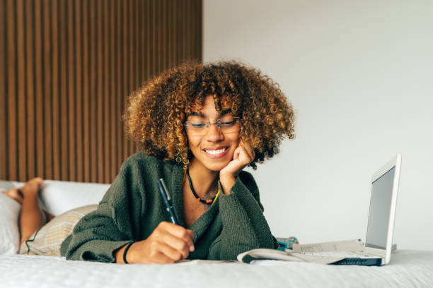 istock Young woman studying in the bedroom bed 1551232204