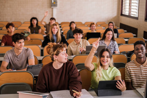 istock Group of college students raising their hands to ask the teacher during class 1551244901