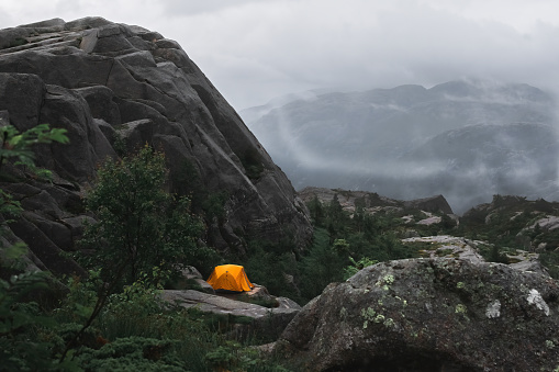 tourists set up an orange tent high in the mountains of Norway