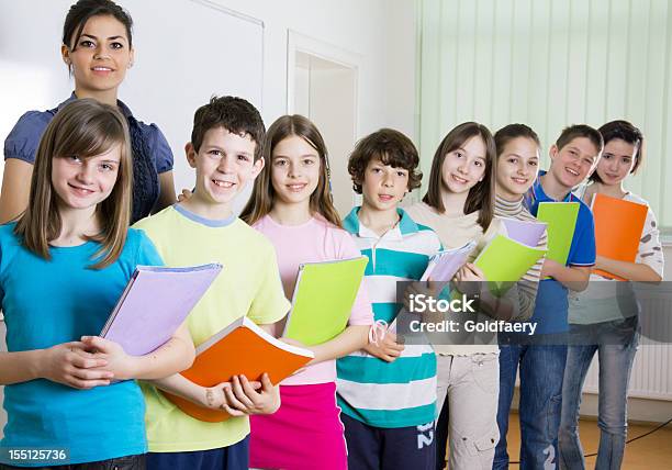 Foto de Professor E Alegre Preteen Estudantes Em Pé Em Sala De Aula e mais fotos de stock de 10-11 Anos