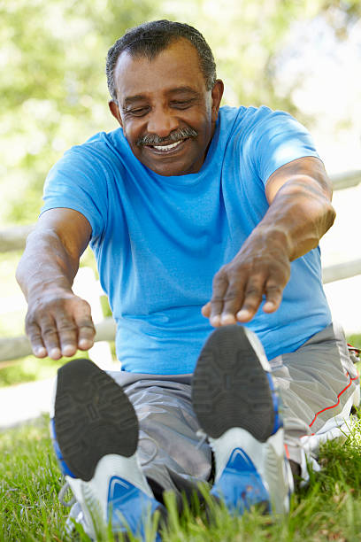 Senior African American Man Exercising In Park  touching toes stock pictures, royalty-free photos & images