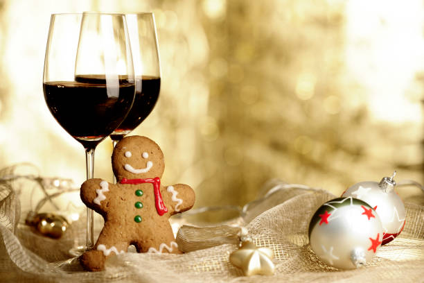 two glasses of red wine, gingerbread man and christmas ornaments - wine christmas stockfoto's en -beelden