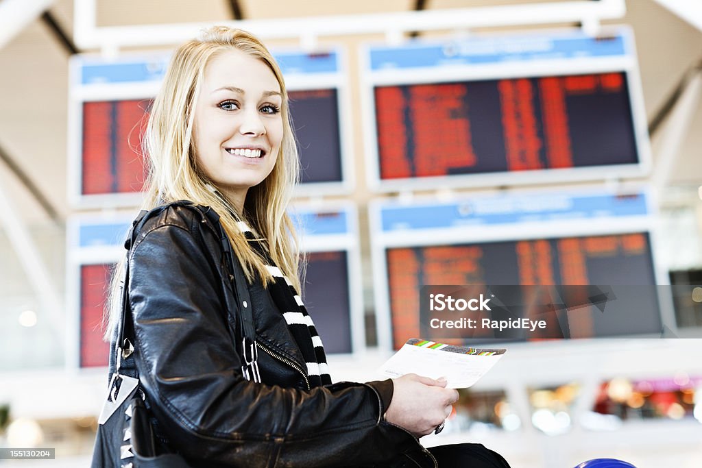 Hermosa rubia que sonrisas, agarrando su pase de abordar en el aeropuerto - Foto de stock de 20 a 29 años libre de derechos