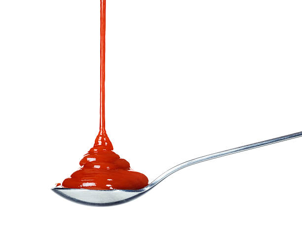 ketchup gießen auf einem löffel - sauces stock-fotos und bilder