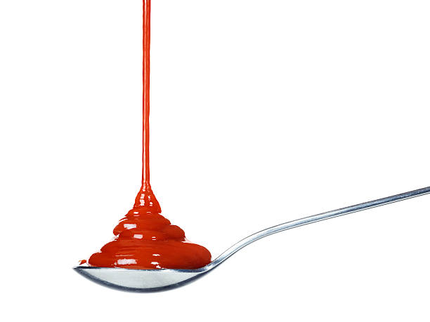 Ketchup pouring on a spoon stock photo