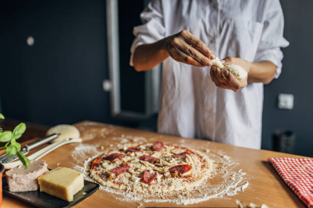 istock A woman prepares a pizza 1551305328