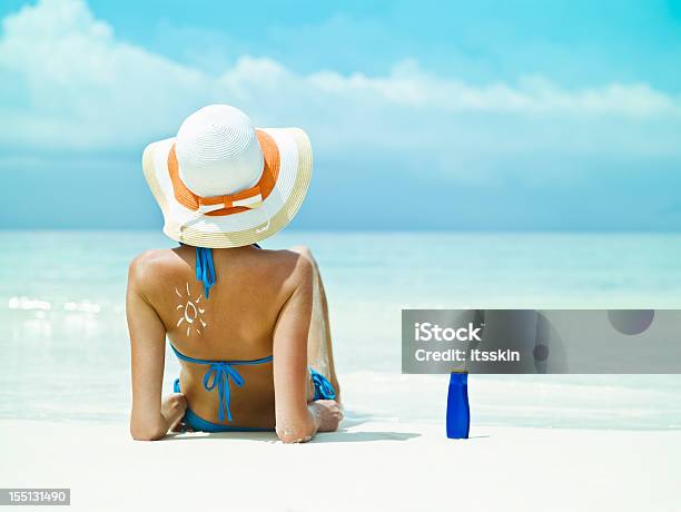 Foto de Sentado Perto Do Mar Com Protetor Solar Em Garrafa e mais fotos de stock de Protetor Solar - Protetor Solar, Mulheres, Só Uma Mulher