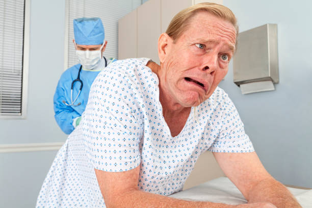 Cancer Screening - iStockMovember2011 A patient makes a face as his doctor performs a prostate examination. cancer screening stock pictures, royalty-free photos & images