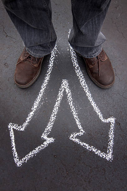 istock Man's feet with two chalk pointing arrows 155131822