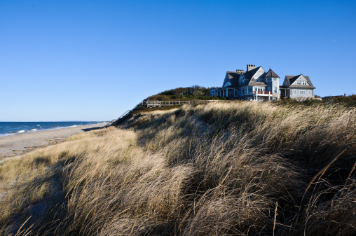 A large home on ther Massachusetts coast sits on a low bluff overlooking the Ocean and Cape Cod Bay.