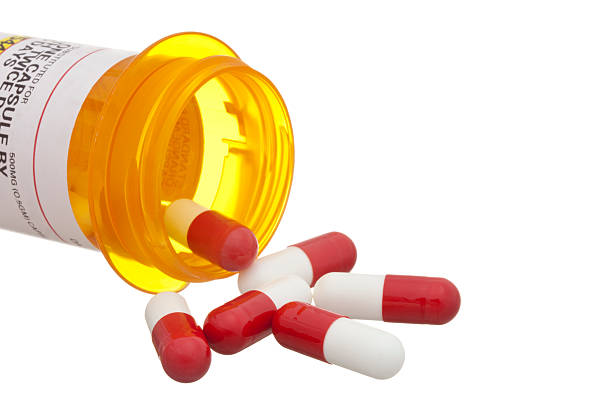 istock Red and white pills spilling from an open medicine bottle 155131941