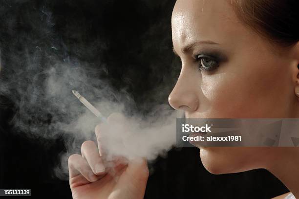 Photo libre de droit de Jeune Femme Au Profil Fumeur En Expirant Fumée Dans Le Nez banque d'images et plus d'images libres de droit de Adulte