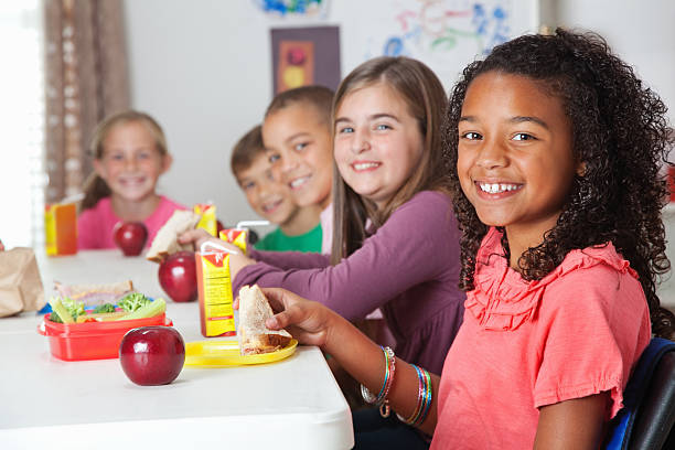 ładny podstawowej dzieci na szkolny lunch - apple eating healthy eating friendship zdjęcia i obrazy z banku zdjęć