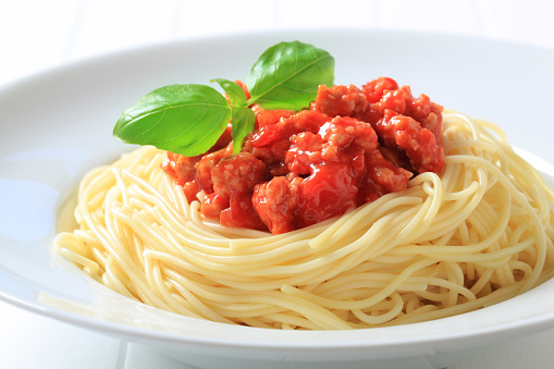 Pasta with traditional tomato sauce on a gray background. Pasta with vegetable sauce. Vegetarian food. Close-up.