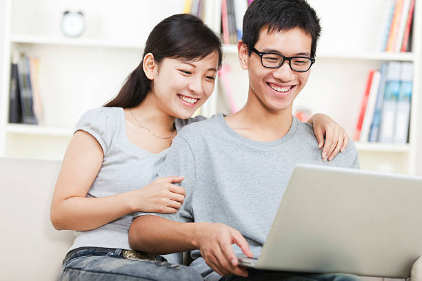 istock happy young couple using laptop at home 155133729