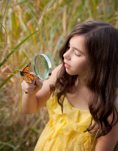 istock Girl with a Magnifying Glass and Monarch Butterfly 155134990