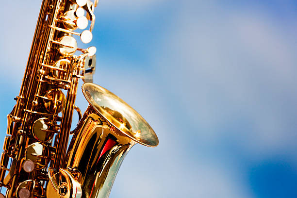 alto "sax primer plano contra el cielo con nubes dispersas - light jazz fotografías e imágenes de stock