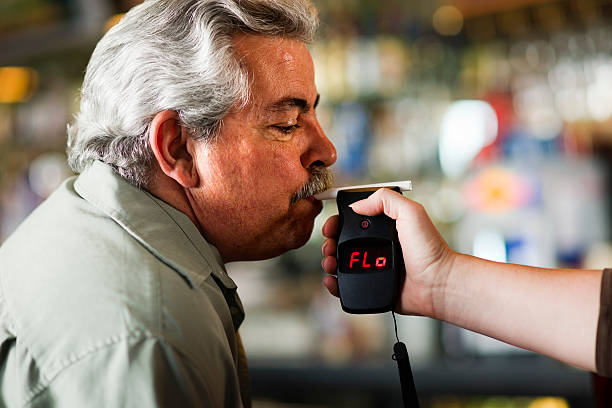 Man taking a breath test held by anther person stock photo