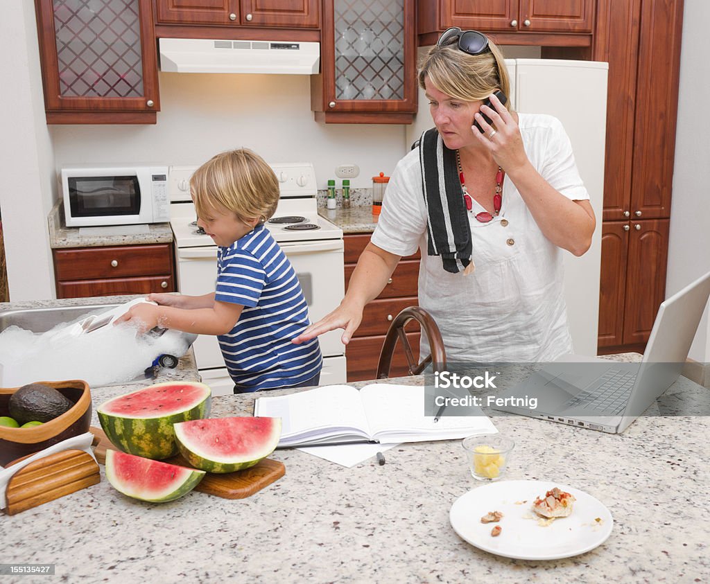 Multitarea madre en su casa - Foto de stock de Caos libre de derechos