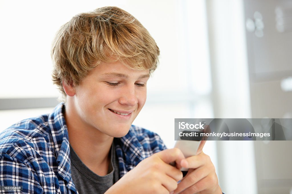 Jeune garçon avec un téléphone de classe - Photo de 16-17 ans libre de droits