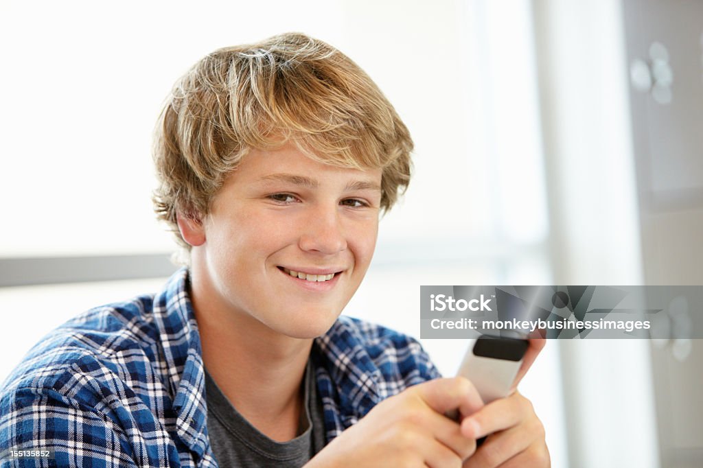 Teenage boy with phone in class  16-17 Years Stock Photo