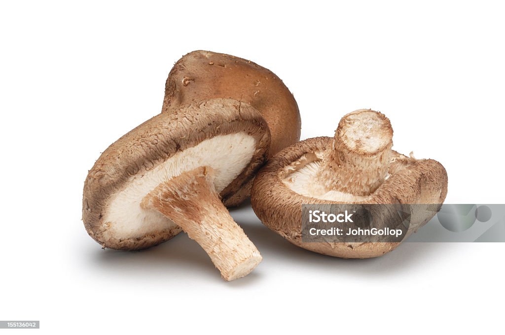 Three shiitake mushrooms isolated on a white background Small group of shitake musrooms isolated on white. Shiitake Mushroom Stock Photo