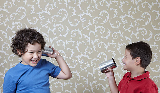 istock Two little boys playing with a tin can telephone 155136699