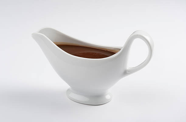 Close-up of a china gravy boat with a white background White china gravy boat isolated on white background.Front view.Single object and no people.There are meat sauce in the gravy boat.Close up. Studio shot,Side view and copy Space.Horizontal photography. gravy stock pictures, royalty-free photos & images
