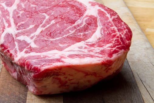 Thick Bone-In Rib Eye Steak on a cutting board