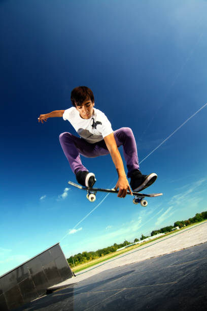istock Young boy jumping in the air on a skateboard 155137362
