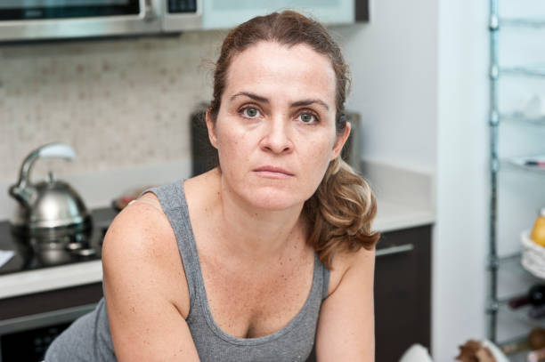 in posa nella sua cucina casalinga - solo una donna matura foto e immagini stock