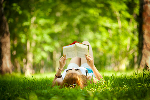 Girl reading a book in the park.