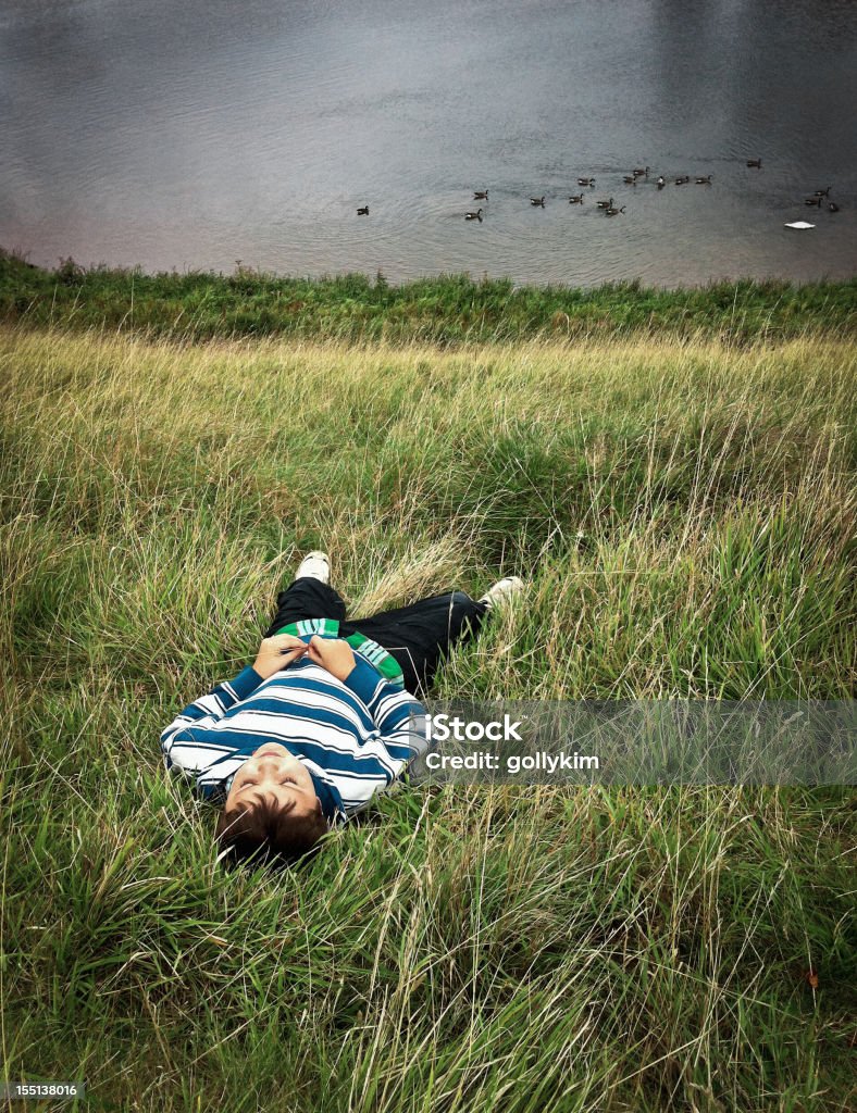 Junge liegen in long grass mit Augen geschlossen - Lizenzfrei Auf dem Rücken liegen Stock-Foto