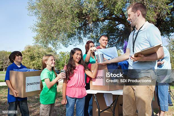 Children And Families Bringing Donations To Relief Center Stock Photo - Download Image Now