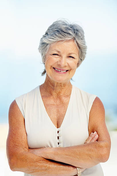 istock Senior woman smiling against a blue sky 155138042