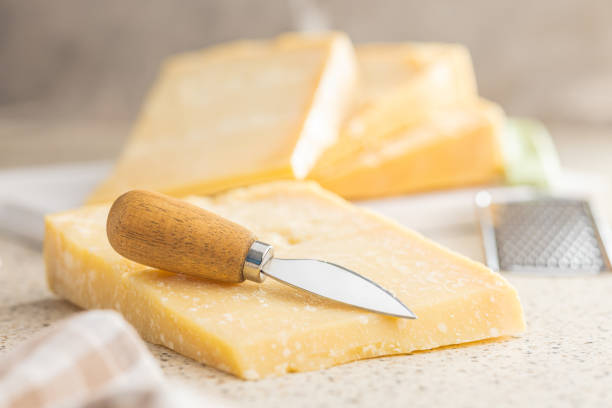 Tasty parmesan cheese on kitchen table. Tasty parmesan cheese on the kitchen table. grana padano stock pictures, royalty-free photos & images