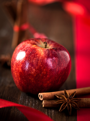 Winter apple decorated with cinnamon, star anis and ribbon