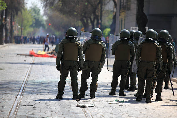 Riot police with a mob in the background stock photo