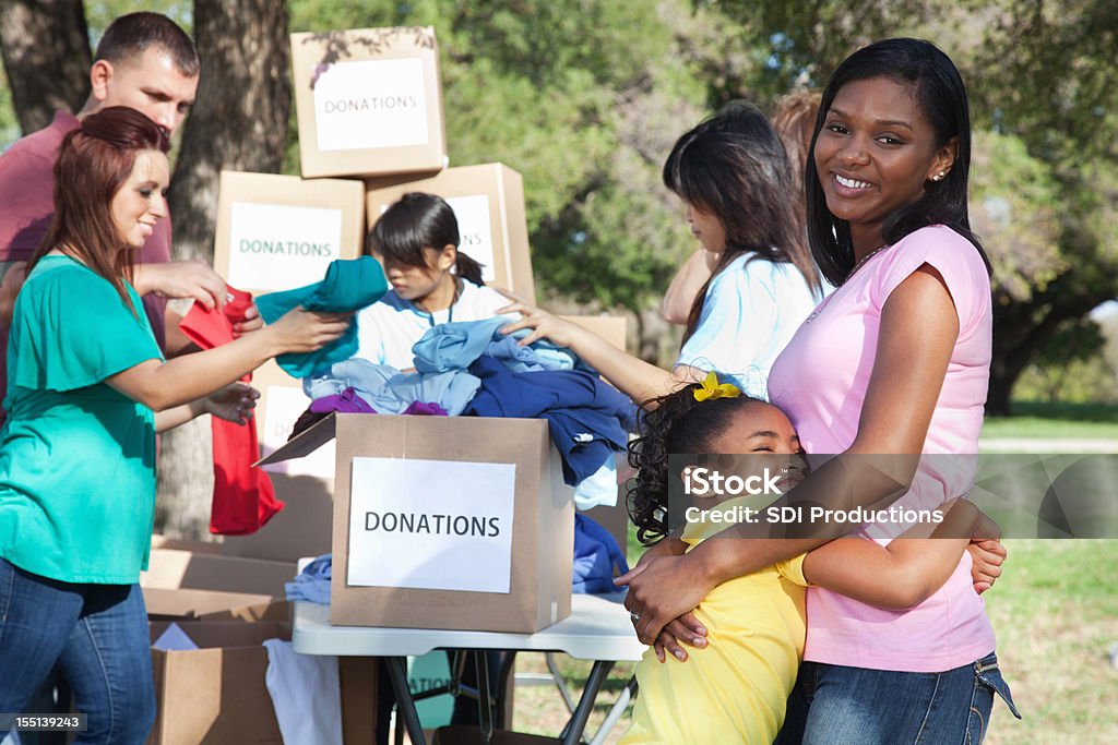 Happy mother and daughter at a donation center Happy mother and daughter at a donation center.  Charitable Donation Stock Photo