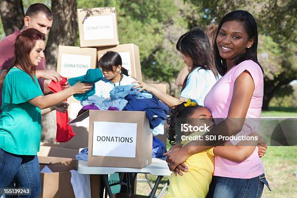 Happy Mother And Daughter At A Donation Center Stock Photo - Download Image Now - Charitable Donation, Donation Box, Clothing